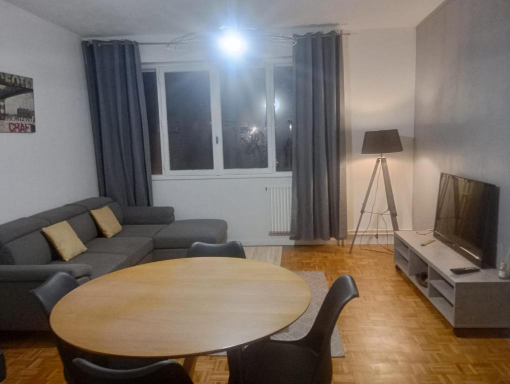 - un salon avec une table, un canapé et une télévision dans l'établissement Pleinitude 4 avec 2 chambres à louer separement, au Mans