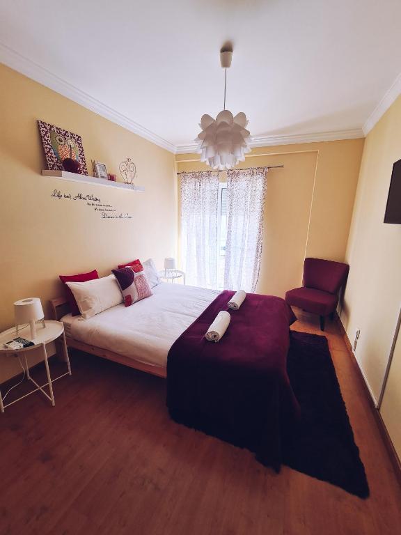 a bedroom with a large bed and a chair at DOWNTOWN-GuestHouse in Olhão