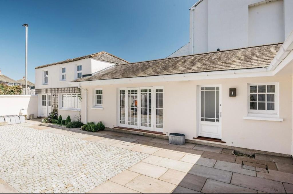a white house with a courtyard in front of it at Mount Auldyn House - The Cottage in Ramsey