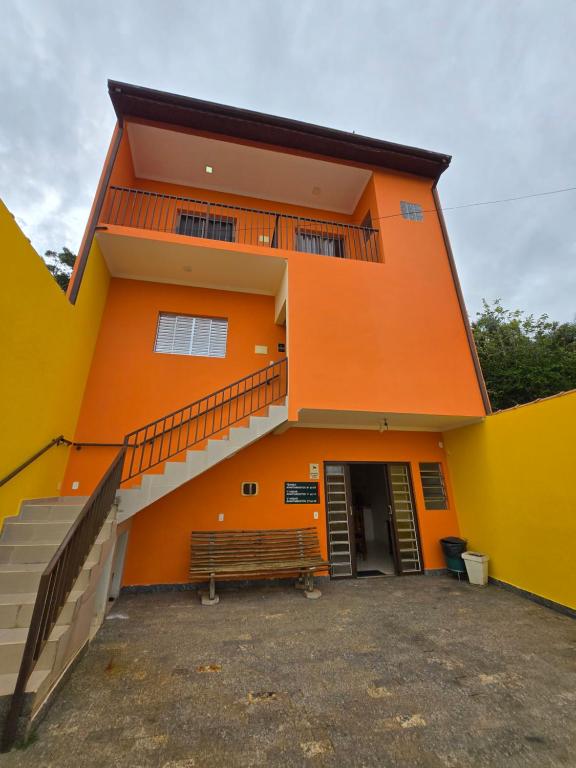 an orange building with a staircase in front of it at Suites Clima da Serra in Cunha