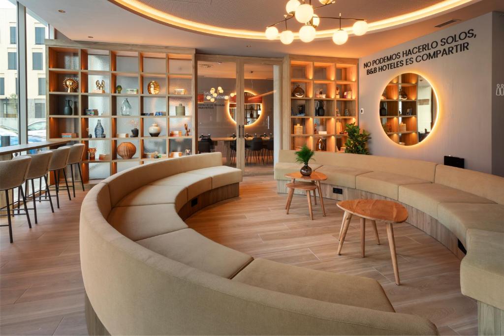 a lobby of a store with a couch and tables at B&B HOTEL Madrid Carabanchel in Madrid