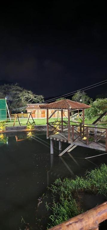 a wooden bridge over a body of water at night at Brisa Suave Serra in Bezerros