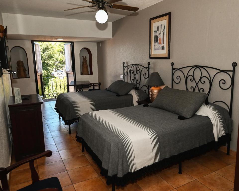 瓦哈卡市Hotel Hacienda的带两张床和吊扇的卧室