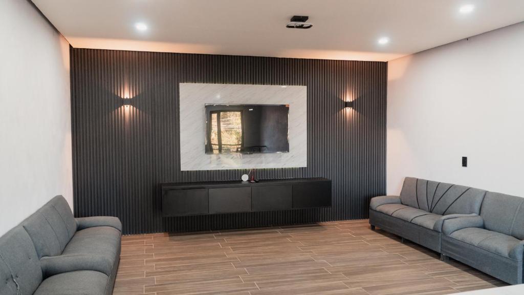 Una sala de estar con dos sofás y un televisor. en Las Piedras Suite, en El Arenal