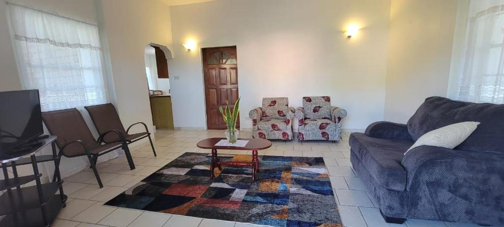 a living room with a couch and a table at Dominic Apt at Mt Hartman in Golflands