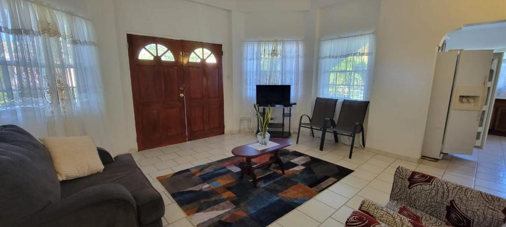 a living room with a couch and a table at Dominic Apt at Mt Hartman in Golflands
