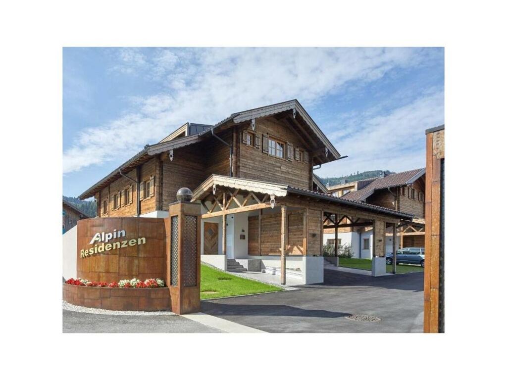 ホラースバッハ・イム・ピンツガウにあるAlpin Residenzen Top 12の目の前に看板が立つ木造建築