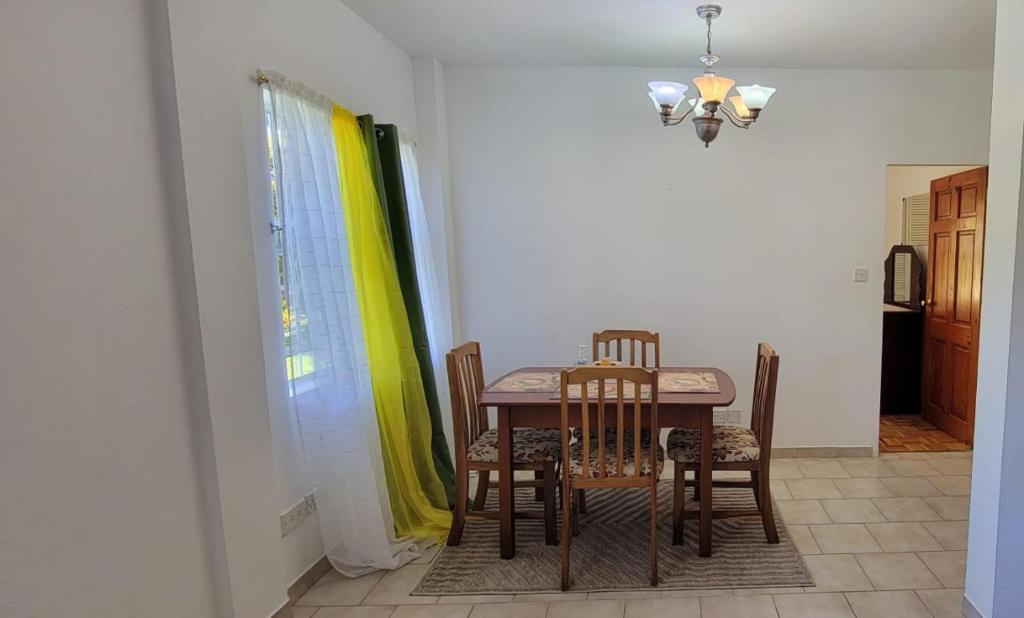a dining room table and chairs in a room at Dominic Apt at Mt Hartman in Golflands