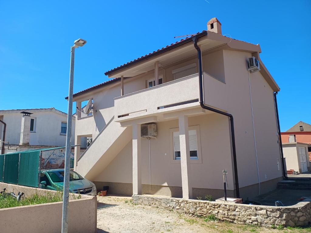 a small white house with a staircase on it at Apartments with a parking space Nin, Zadar - 23493 in Nin