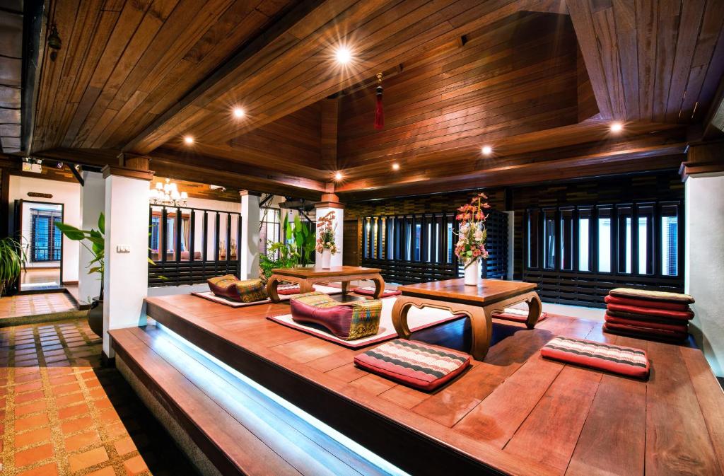 ein Wohnzimmer mit Holzdecken, einem Sofa und Tischen in der Unterkunft Yotaka Boutique Hotel Bangkok in Bangkok
