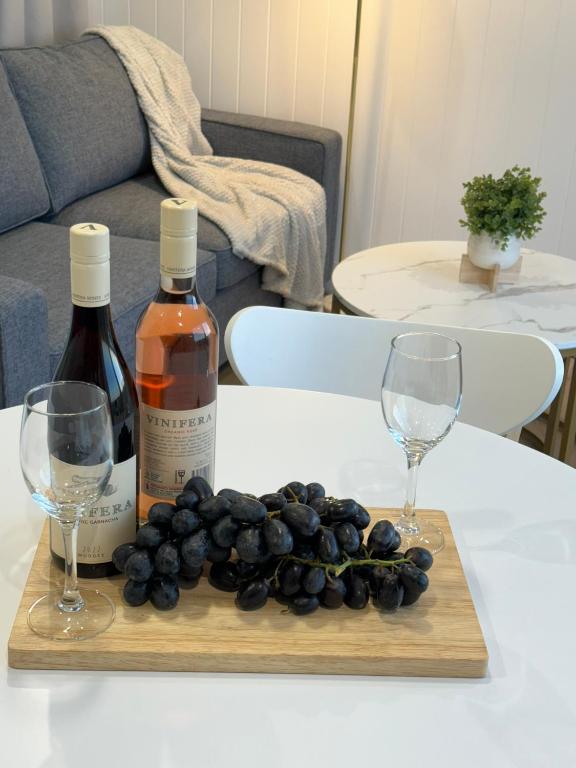 two bottles of wine and two wine glasses on a table at Kingdom Cottages in Gulgong