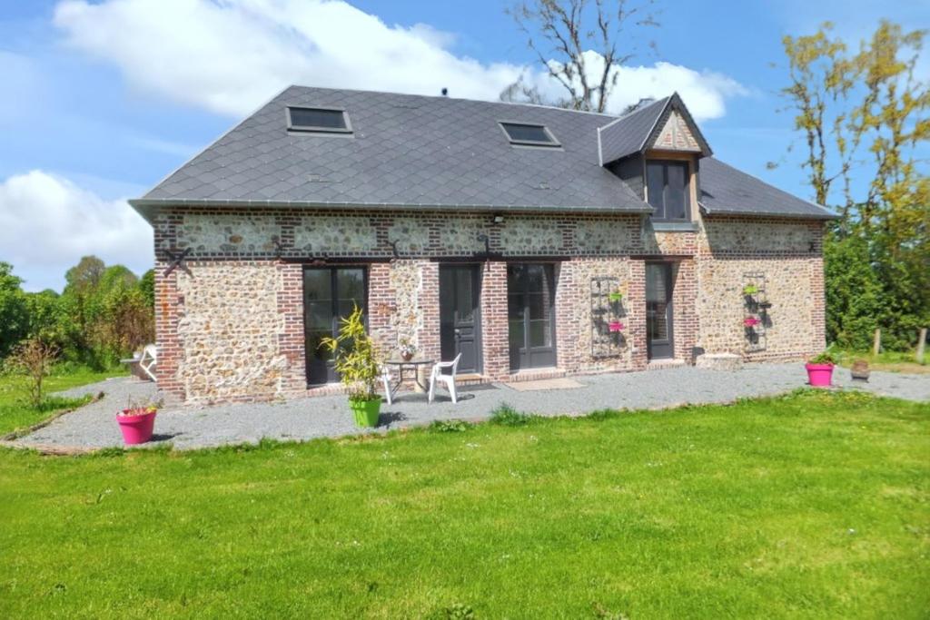 a brick house with a lawn in front of it at Charmante Maison à Fort-Moville avec Terrasse Privée in Fort-Moville