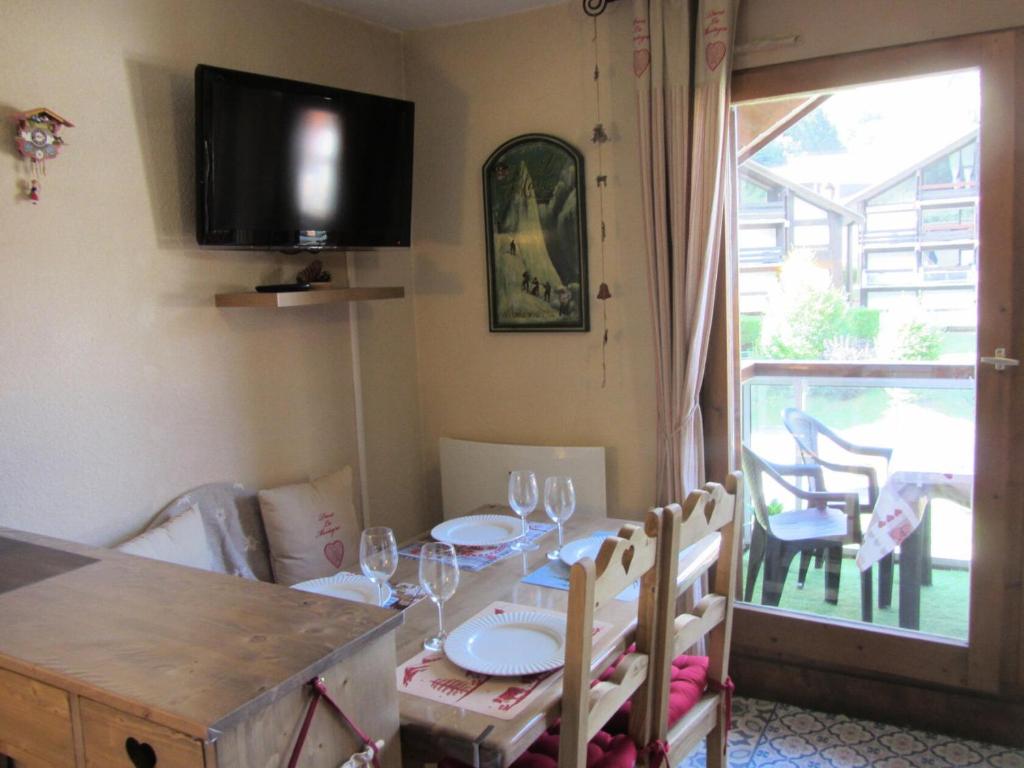 une salle à manger avec une table avec des chaises et une télévision dans l'établissement Résidence Combettes - Combettes E288 MAE-5071, aux Contamines-Montjoie