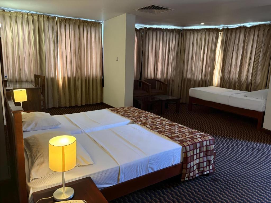 Postel nebo postele na pokoji v ubytování Hotel Janaki