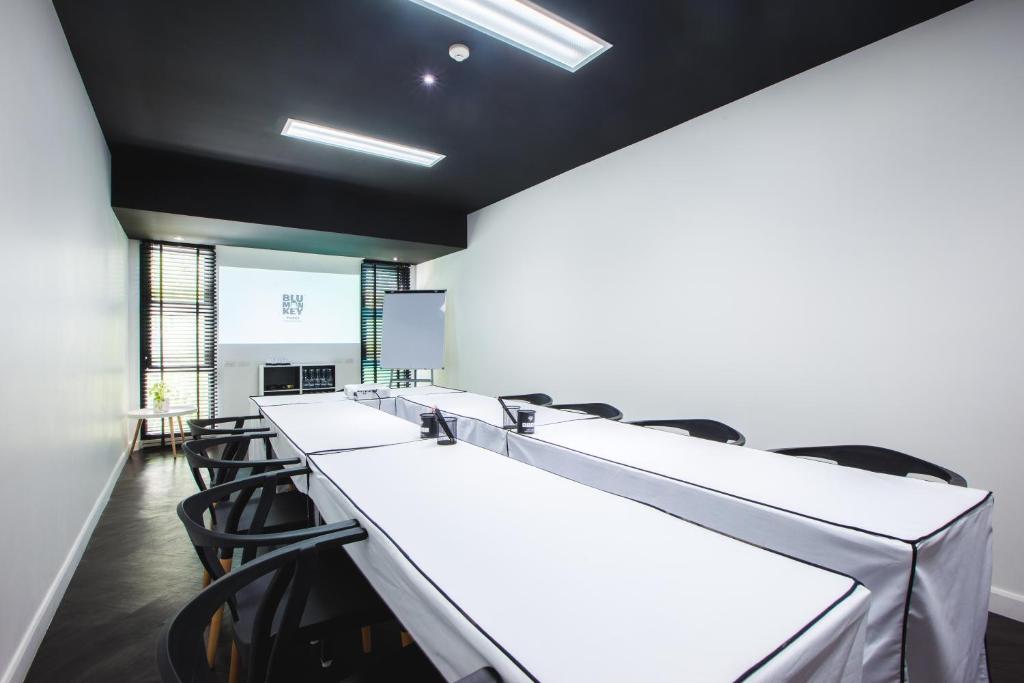 a conference room with a row of tables and chairs at Blu Monkey Hub and Hotel Phuket Town- Free All Day Coworking space in Phuket Town