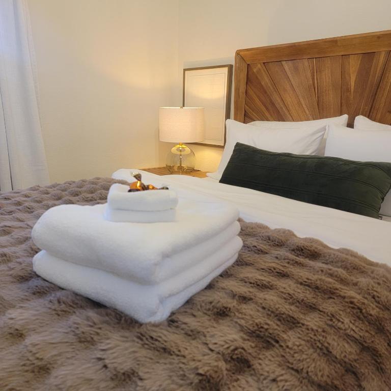 a bed with a pile of white towels on it at My Casitas in Phoenix