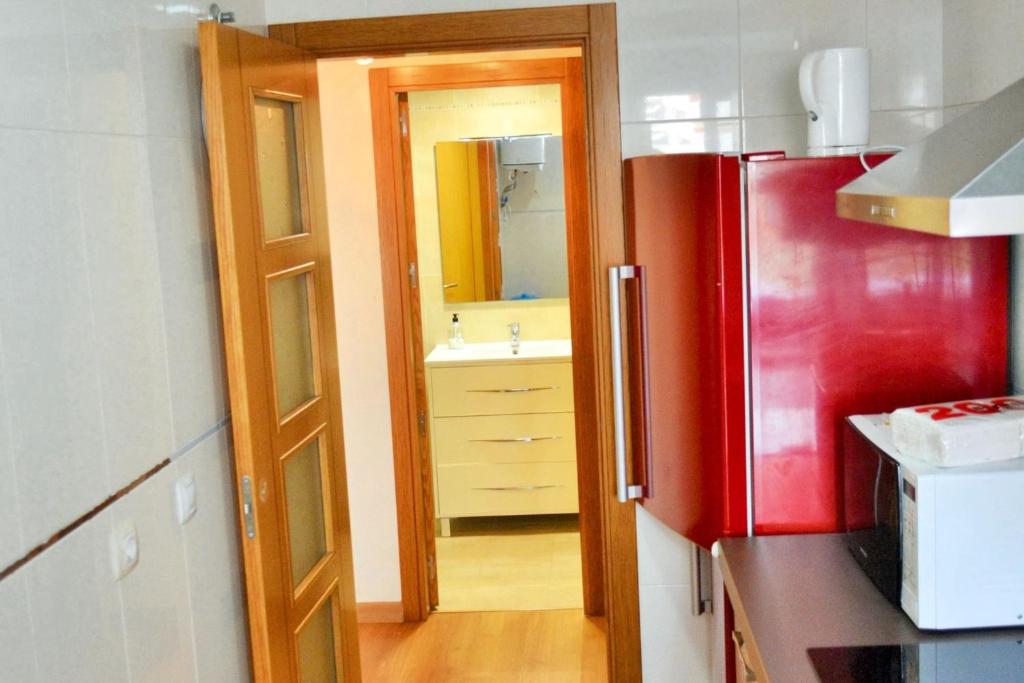 kuchnia z czerwoną lodówką i zlewem w obiekcie Modern Apartment Málaga 80 m² + Balcony w Maladze