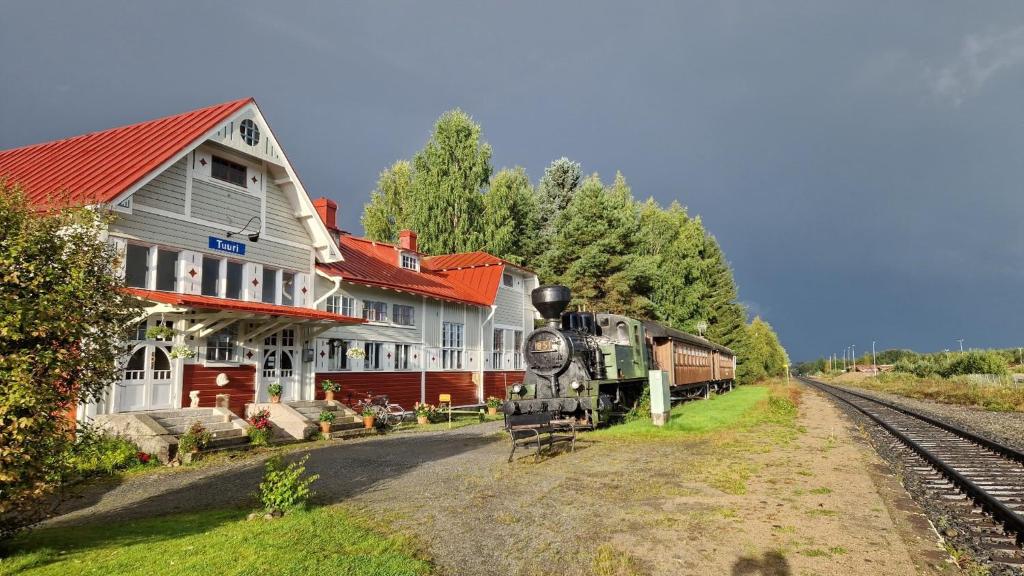 a train is parked in front of a train station at Junamajoitus Tuuri Train Station in Tuuri