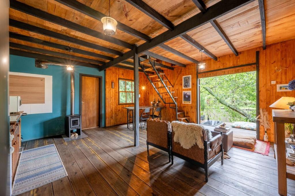 ein Wohnzimmer mit Holzwänden und Holzböden in der Unterkunft Cabana aconchegante em meio à natureza in Morro Reuter