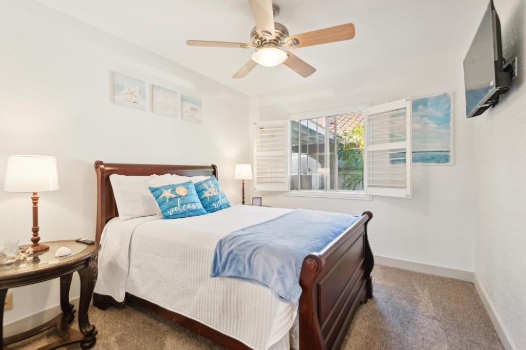 Un dormitorio con una cama y un ventilador de techo. en Peaceful Oasis, en Anaheim
