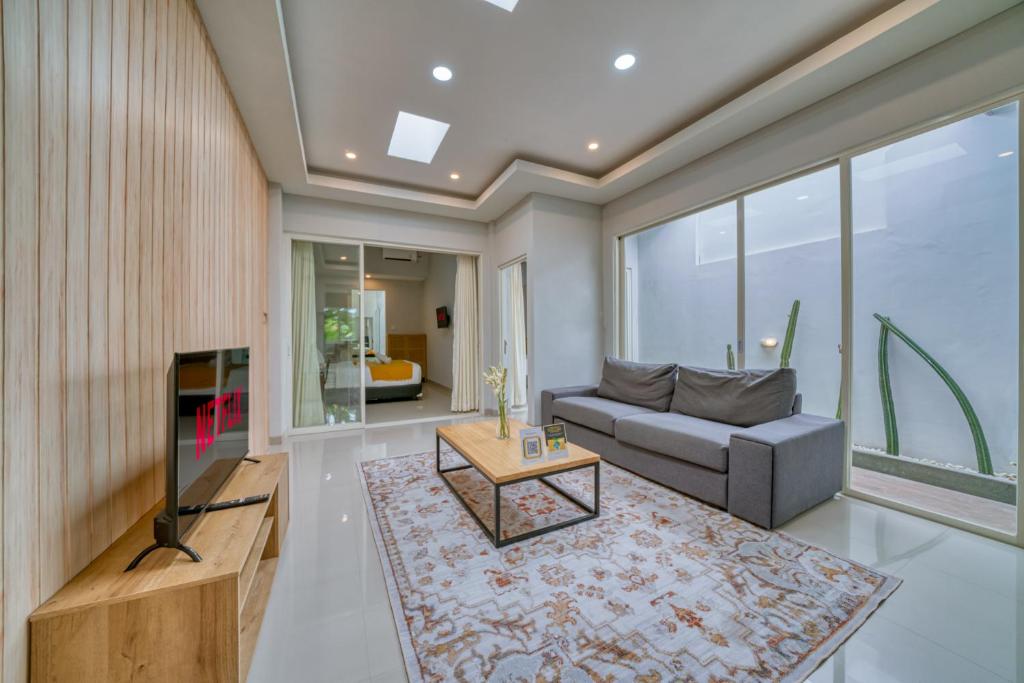 a living room with a couch and a tv at Petite 2bd Fully Equipped Home in Canggu in Kerobokan