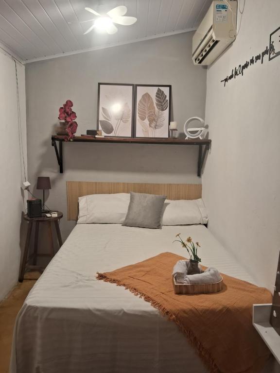 a bedroom with a large bed with a brown blanket at Aconchego Suíte in Prado