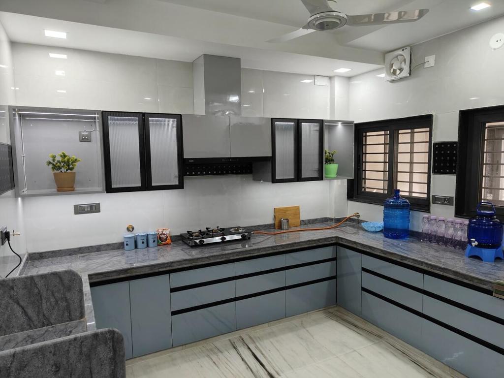 a kitchen with gray cabinets and a counter top at Luxurious 2 BHK Apartment - Home away from Home ! in Udaipur