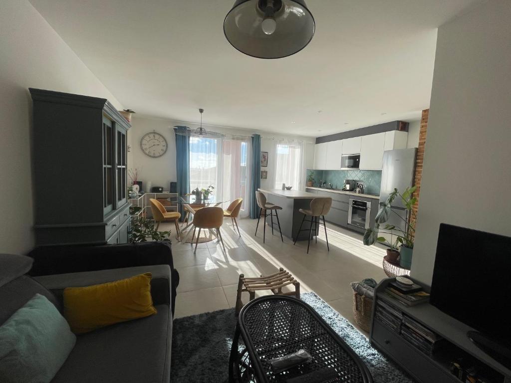 un salon avec un canapé et une salle à manger dans l'établissement T2 vue Pyrénées au Sud de Toulouse, à Toulouse