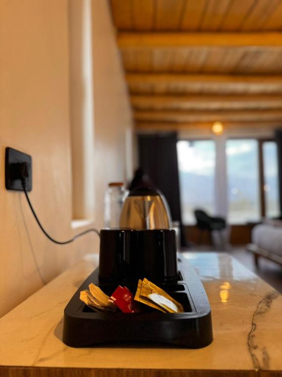 una macchinetta del caffè seduta su un bancone in una stanza di Yeti Resort Hunder a Hundar