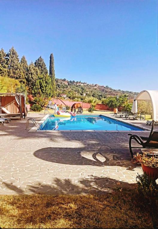 a large swimming pool with people in it at Villa Alessio - Etna Historic Winery Villa - Ancient Palmento with pool in Puntalazzo