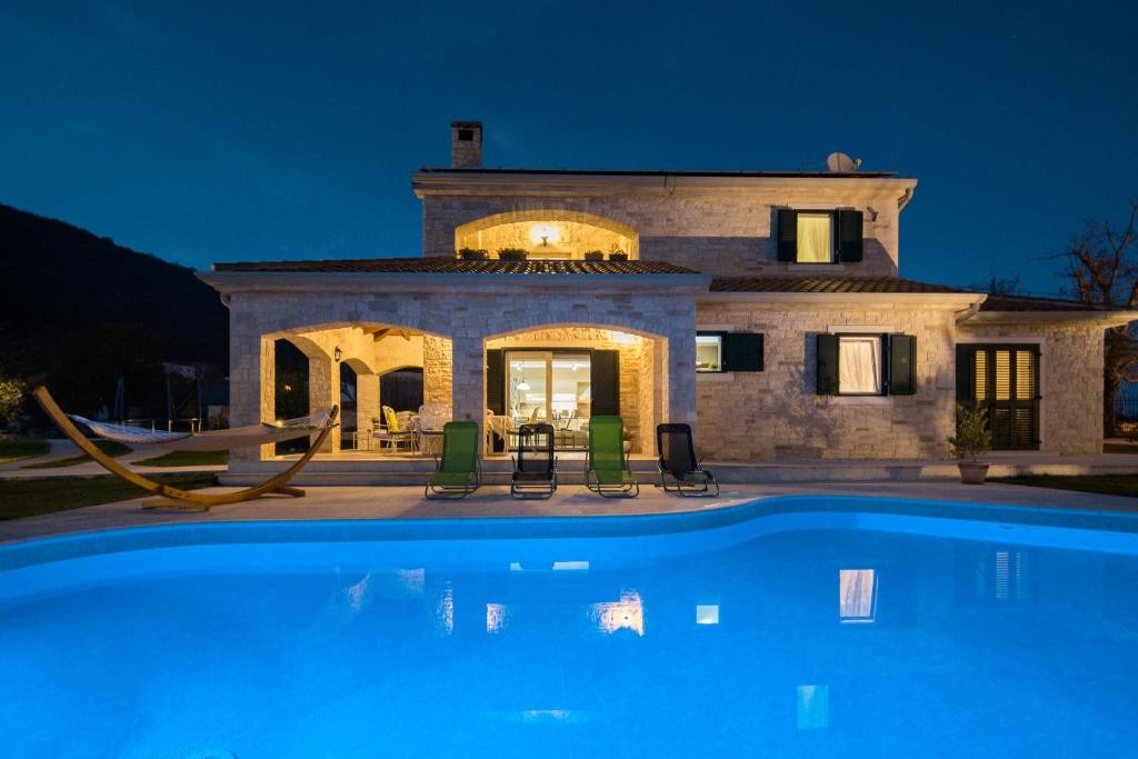 a house with a swimming pool in front of it at Villa Stonegate Estate - Bonus, dvije vile jedna cijena! in Opatija