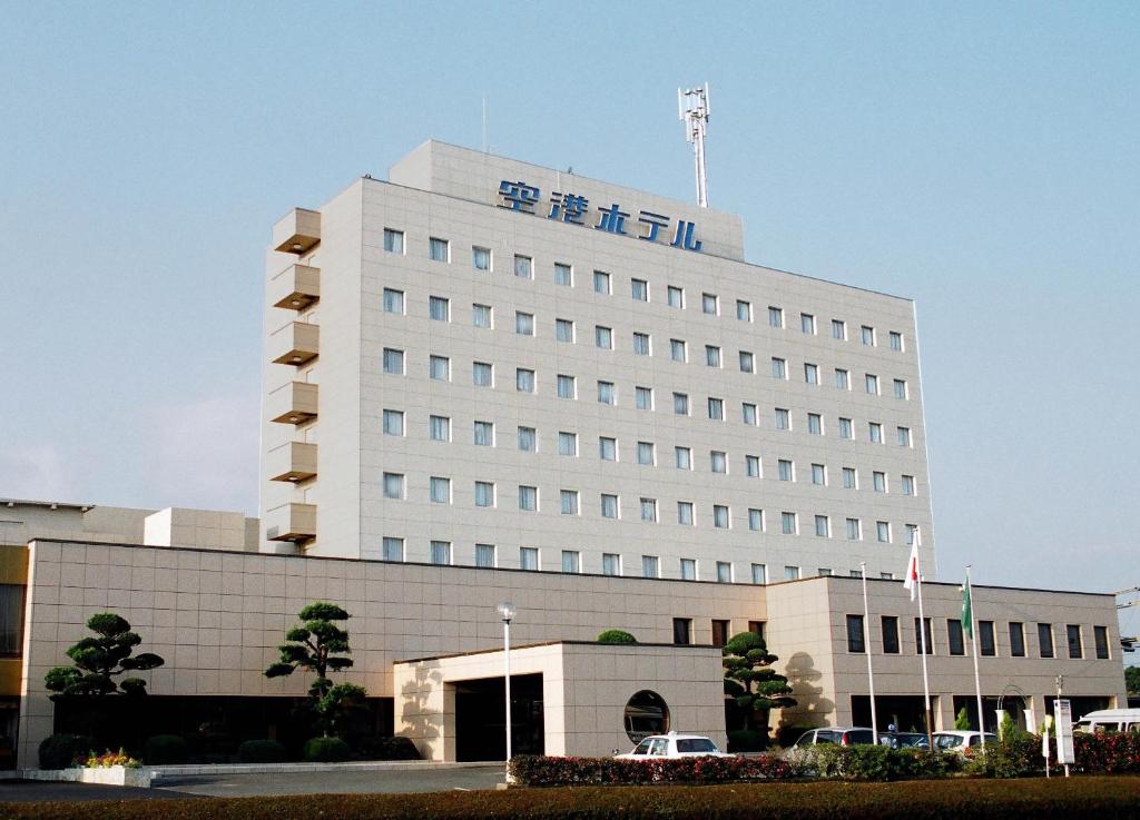 un gran edificio blanco con un cartel encima en Kagoshima Kuko Hotel, en Kirishima