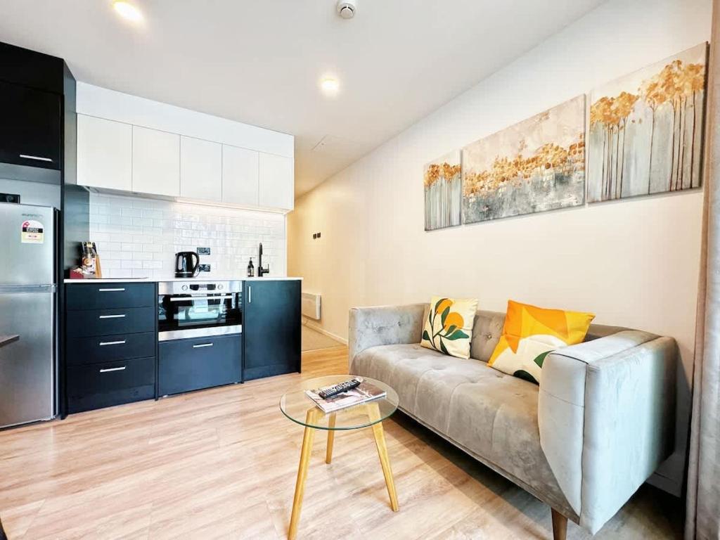 a living room with a couch and a kitchen at Central Location Cozy Studio with Pool Gym & Sauna Nearby Skytower in Auckland