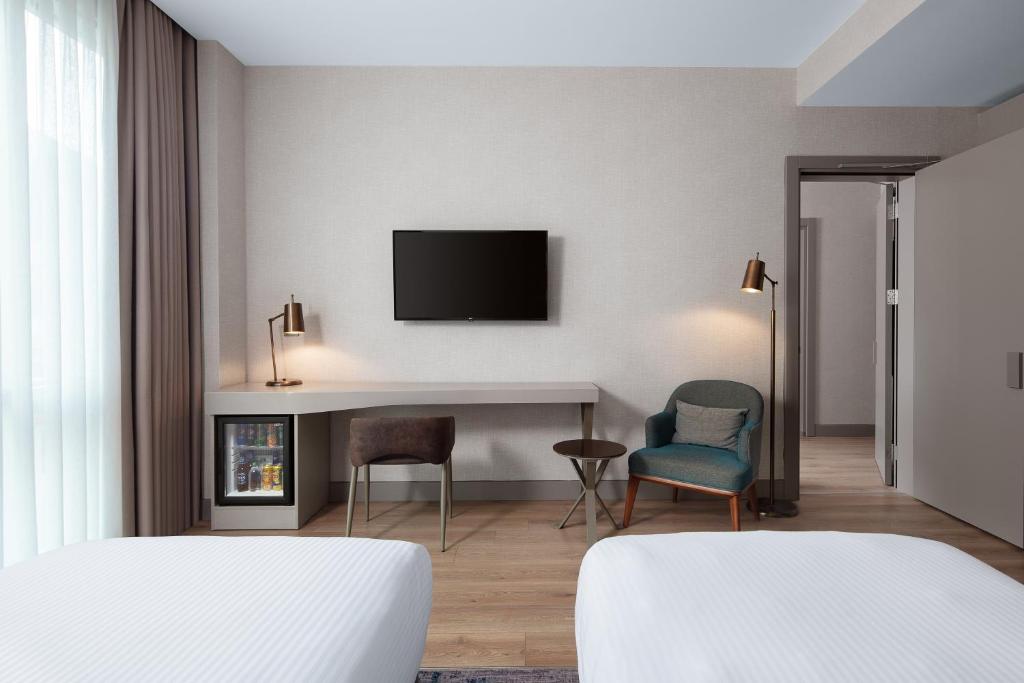 a hotel room with a tv and a table and chairs at Delta Hotels by Marriott Istanbul Vadi in Istanbul