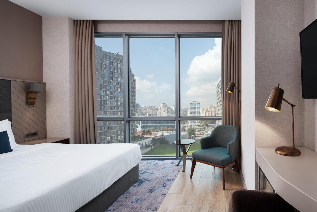 a hotel room with a bed and a large window at Delta Hotels by Marriott Istanbul Vadi in Istanbul