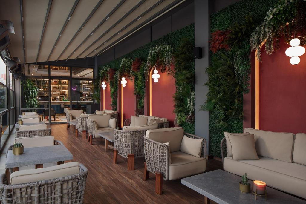 a restaurant with couches and tables and plants on the wall at Delta Hotels by Marriott Istanbul Vadi in Istanbul