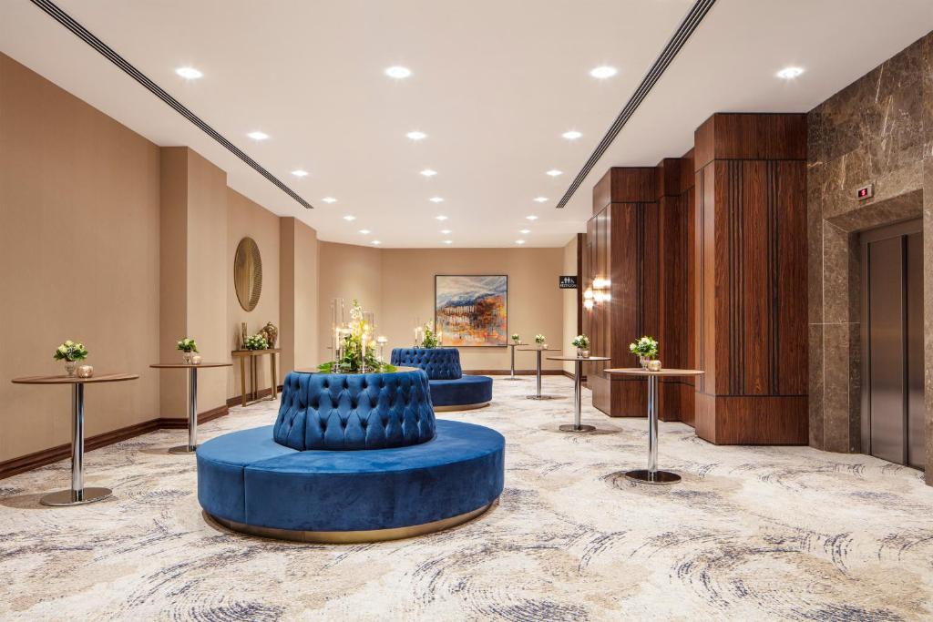 a lobby with two blue chairs and tables at Delta Hotels by Marriott Istanbul Vadi in Istanbul