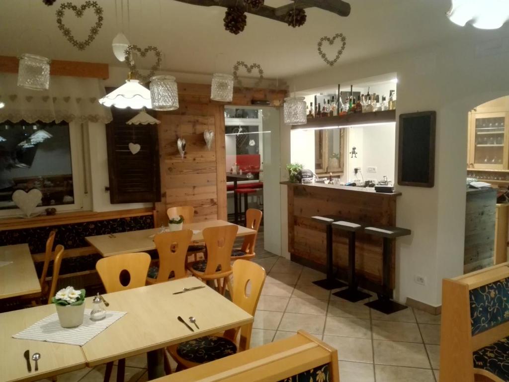 a restaurant with tables and chairs and a kitchen at Pension Sonnalp in Ortisei