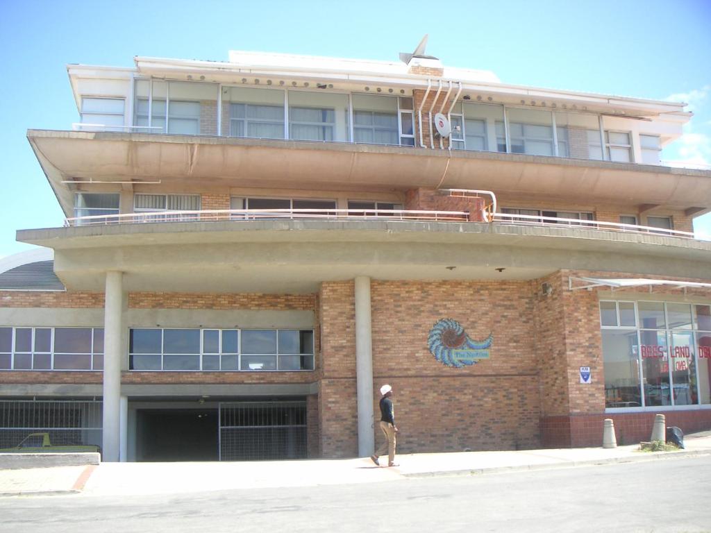 a man standing in front of a building at Waterside Living NT01 in Jeffreys Bay