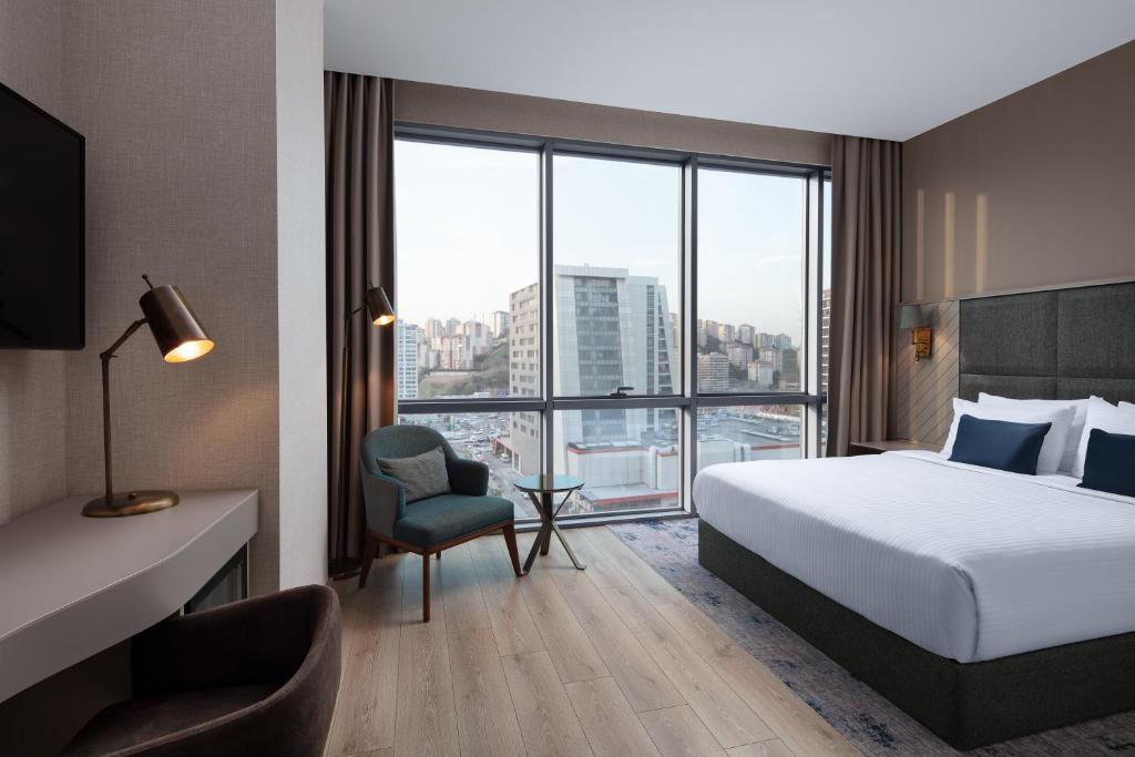 a hotel room with a bed and a large window at Delta Hotels by Marriott Istanbul Vadi in Istanbul