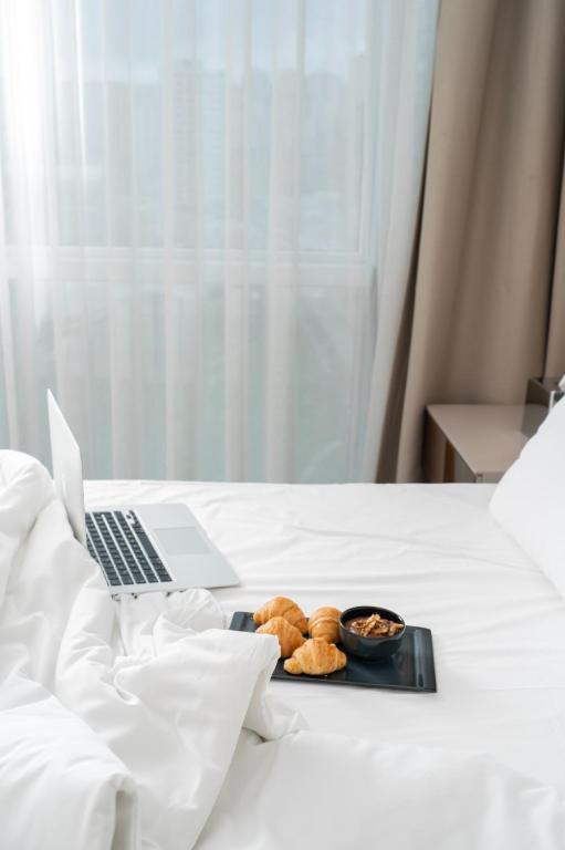 a tray of cookies and a laptop on a bed at Delta Hotels by Marriott Istanbul Vadi in Istanbul