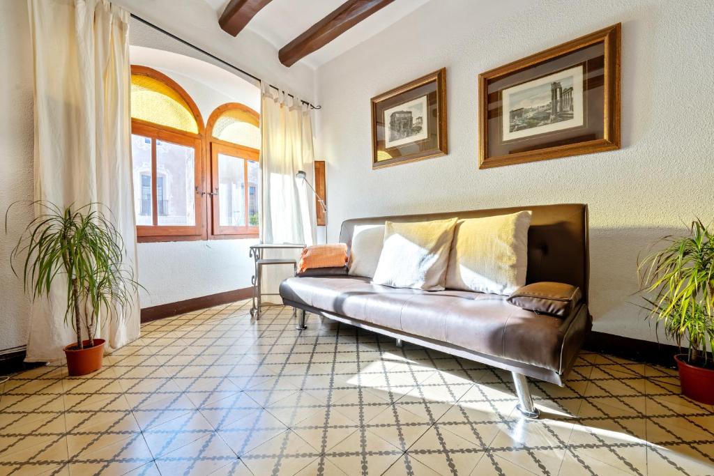 a living room with a leather couch and a window at Ca La Maria in Santes Creus