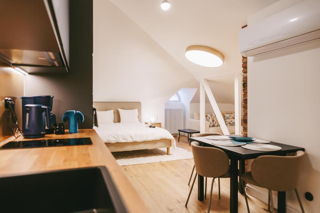 a bedroom with a bed and a table with chairs at Kullassepa Boutique Apartments - Square View in Tallinn