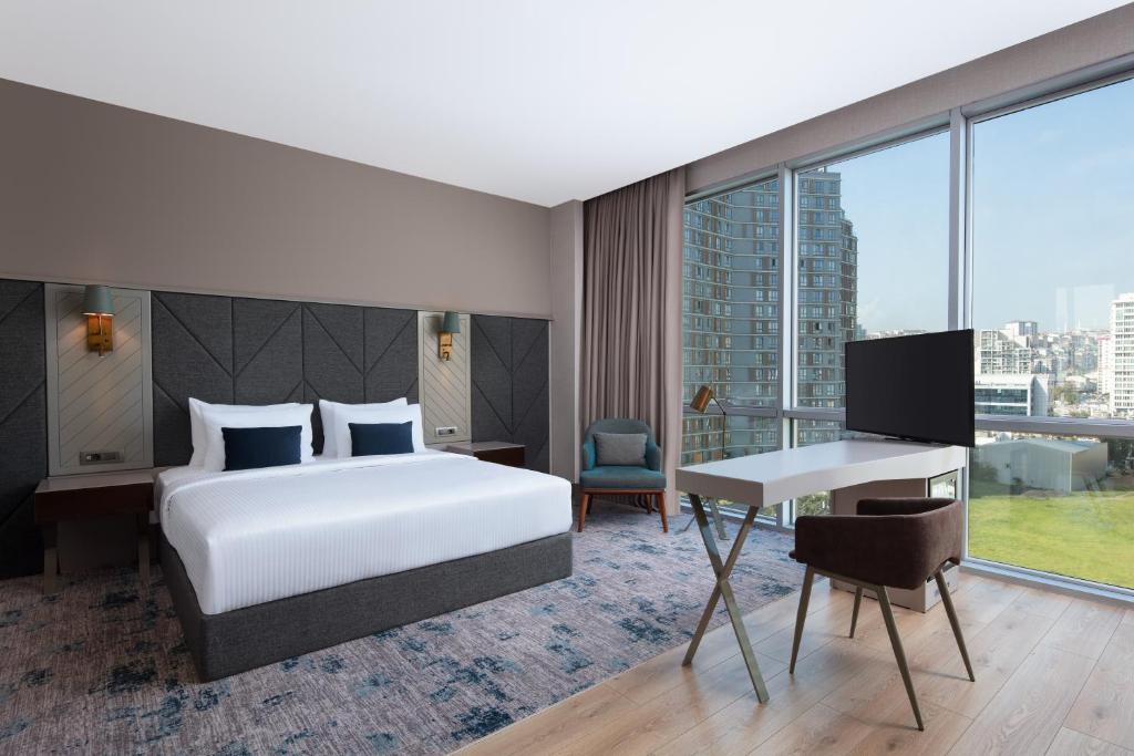 a hotel room with a bed and a desk at Delta Hotels by Marriott Istanbul Vadi in Istanbul
