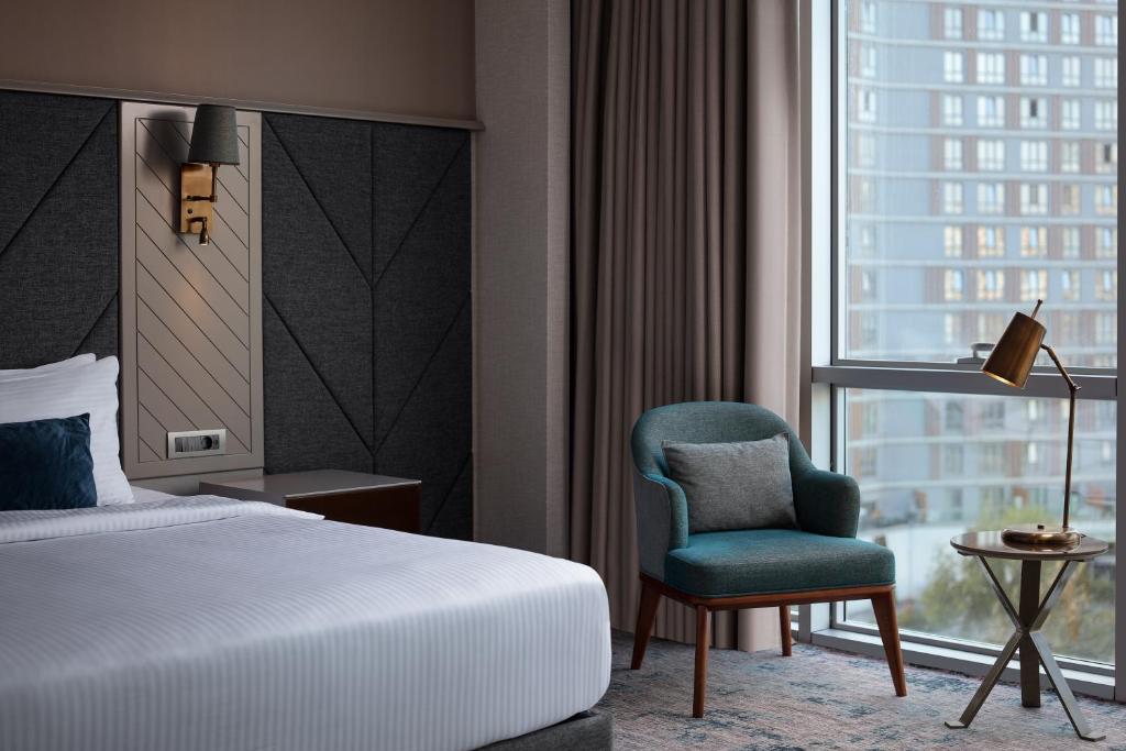 a bedroom with a bed and a chair and a window at Delta Hotels by Marriott Istanbul Vadi in Istanbul