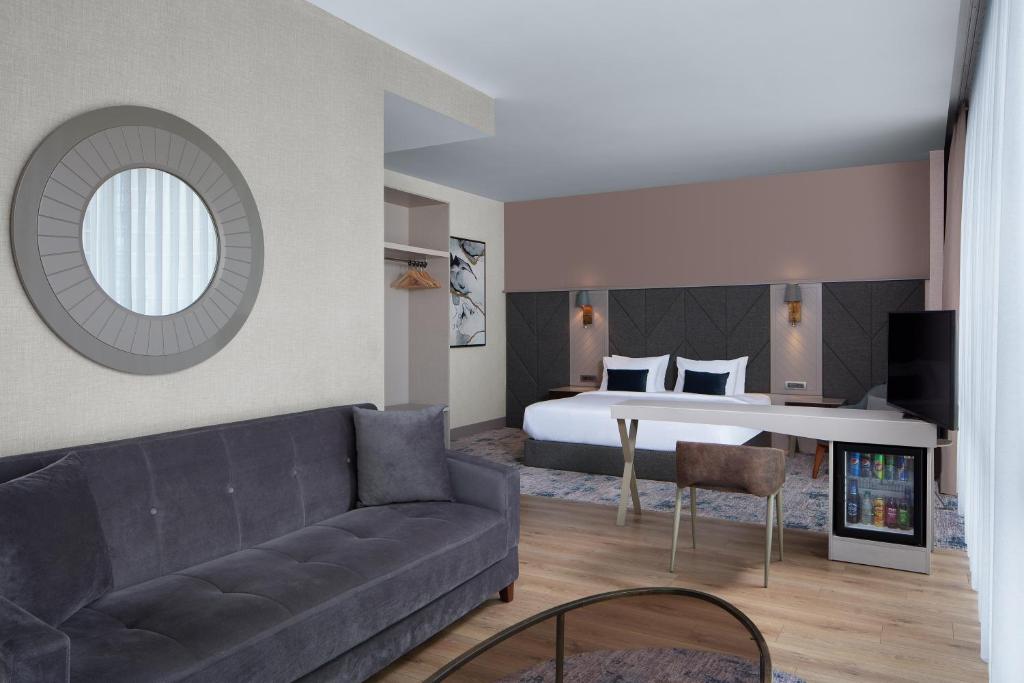 a living room with a couch and a bed at Delta Hotels by Marriott Istanbul Vadi in Istanbul