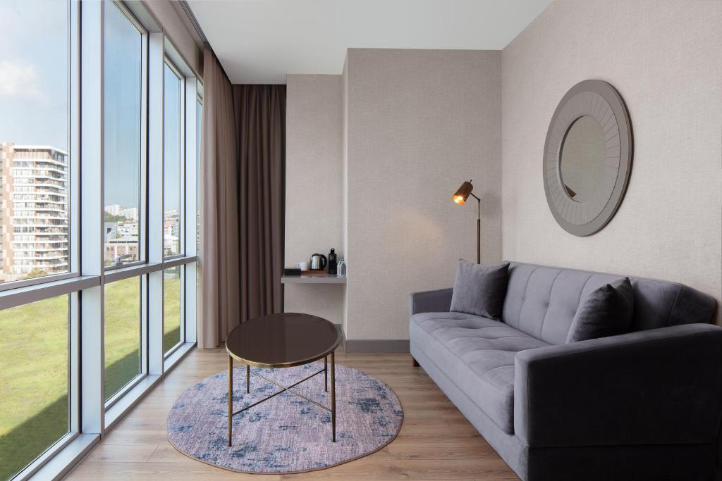 a living room with a couch and a table at Delta Hotels by Marriott Istanbul Vadi in Istanbul
