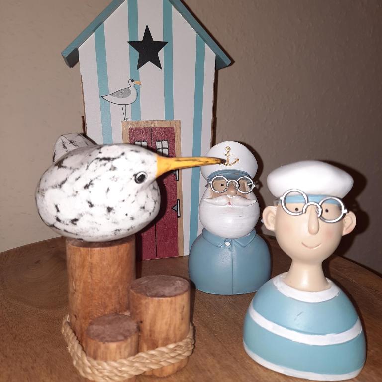 a table topped with figurines of a bird and a cake at Kiteblick in Büsum