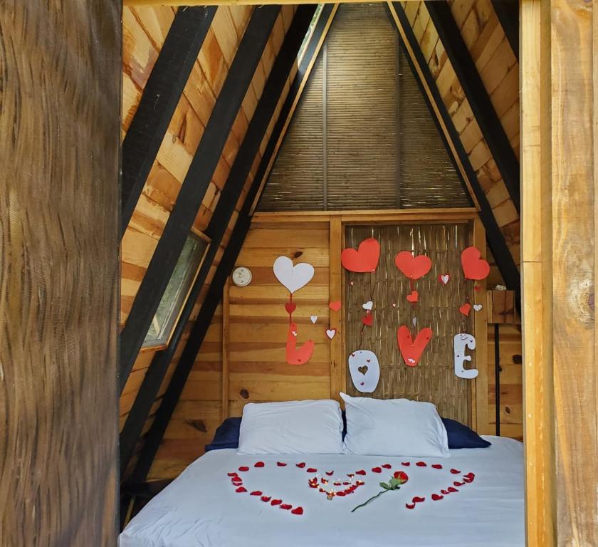 a bed in a room with hearts on the wall at New Natural Paradise Amazing Pet Friendly Cabin in Xoxocotla