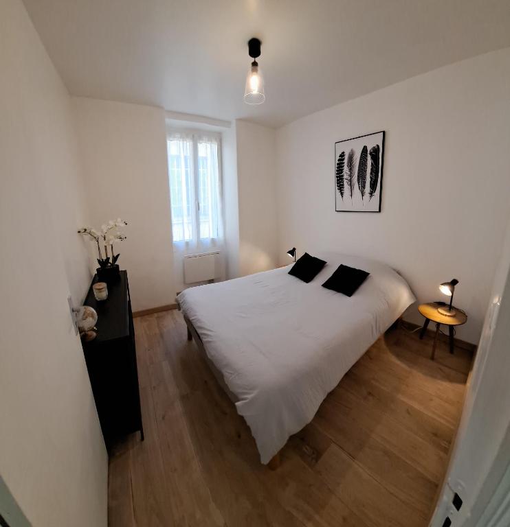 une chambre avec un lit blanc et un parquet dans l'établissement Zenappart - Charmant appartement P2 proche centre ville, à Nîmes